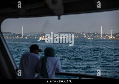 Istanbul, Turquie. 13 juillet 2023. Les gens vus voyager dans la zone ouverte de la ville lignes ferry avec le Bosphore en arrière-plan pendant le temps chaud à Istanbul. (Image de crédit : © Onur Dogman/SOPA Images via ZUMA Press Wire) USAGE ÉDITORIAL SEULEMENT! Non destiné à UN USAGE commercial ! Banque D'Images