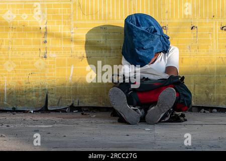 Istanbul, Turquie. 13 juillet 2023. Un homme se couvre du soleil en étant assis par terre près du quai de Kadikoy pendant le temps chaud à Istanbul. (Image de crédit : © Onur Dogman/SOPA Images via ZUMA Press Wire) USAGE ÉDITORIAL SEULEMENT! Non destiné à UN USAGE commercial ! Banque D'Images