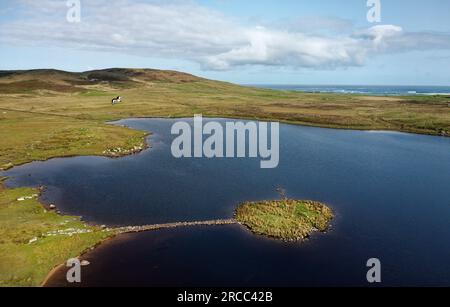 Îlot Eilean Domhnuill dans le Loch Olabhat, N. Uist, Écosse. Site d'habitation préhistorique de 5000 ans du Néolithique précoce de crannog montrant une chaussée. Vue sur NW Banque D'Images