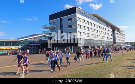 Les spectateurs se promènent le long de Hamilton Straight devant l'hôtel Silverstone Megastore et Hilton Silverstone sur le circuit de Silverstone, dans le Northamptonshire Banque D'Images