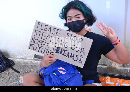 Une manifestante pro-démocratie, un partisan du Move Forward Party, à Bangkok, en Thaïlande, tient une pancarte qui dit : s'il vous plaît, arrêtez de voler nos espoirs, nos rêves et notre avenir. Les manifestants soutiennent Pita Limjaroenrat, du parti Move Forward, qui a remporté le plus de voix aux dernières élections législatives. Pita Limjaroenrat a perdu le vote pour devenir Premier ministre, 51 voix de moins que les 376 voix nécessaires. Le vote a vu de nombreuses abstentions de la part de certains sénateurs. Banque D'Images