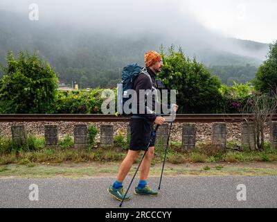 11 juin 2023, Caminha, Viana do Castelo, Portugal : un pèlerin est vu marchant un matin brumeux. La route côtière du Camino portugais est une belle promenade alternative à la route centrale. La distance totale de la route est de 280 km. Il commence à Porto et suit la côte jusqu'à Redondela en Espagne où il fusionne avec la route centrale. Environ 30% des pèlerins qui terminent le Camino portugais marchent sur la voie côtière. Le Camino portugais devient de plus en plus populaire, et de nombreux pèlerins choisissent cet itinéraire comme alternative au Camino Frances. La route côtière du Camino portugais est Banque D'Images