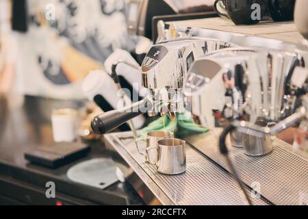 Une petite entreprise de café. Prépare un espresso, Americano avec un plat à emporter. Un barista professionnel prépare le café dans une machine à café à caroube. Travail favori dans Banque D'Images