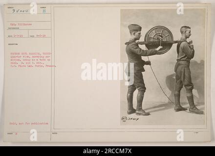 Légende : soldat tenant un porte-bobine de tranchée dans une vue de trois quarts, l'utilisant comme bobine réceptrice. Prise le 6 septembre 1918 par le caporal Hillhouse. Photo prise au R. et I. Division, signal corps photo Lab à Paris, France. Cette photographie est conservée, elle n'est pas destinée à être publiée. Banque D'Images