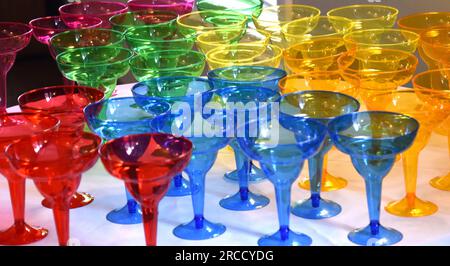 Grande collection de verres à boire aux couleurs vives pour une fête sur une table. Banque D'Images