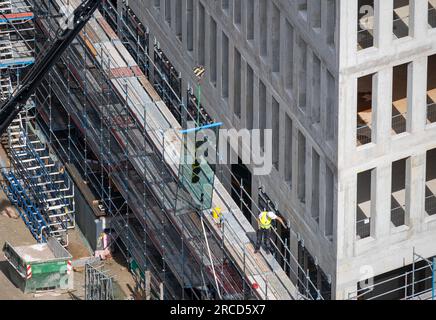 Vitrier installant des fenêtres sur un bâtiment commercial. Banque D'Images