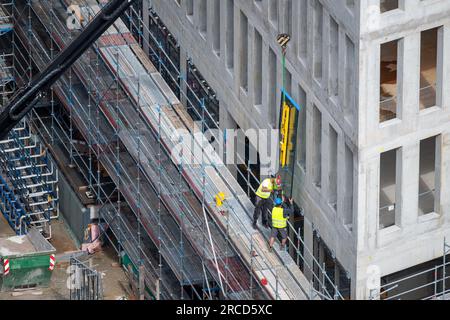 Vitrier installant des fenêtres sur un bâtiment commercial. Banque D'Images