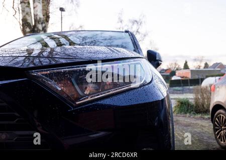 Brecht, Belgique - 21 janvier 2022 : portrait du phare droit d'une toyota rav4 hybride bleu foncé garée dans une allée. Le véhicule peut rouler Banque D'Images