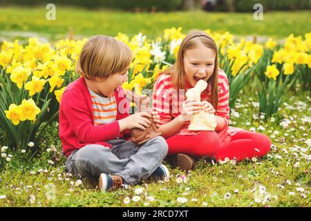 Petits enfants mignons, grande sœur et petit frère, avec des lapins de Pâques en chocolat célébrant la fête traditionnelle. Famille, vacances, printemps, enfant insouciant Banque D'Images