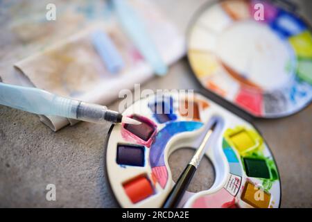 Fort d'aquarelles et les pinceaux sur une table. Banque D'Images