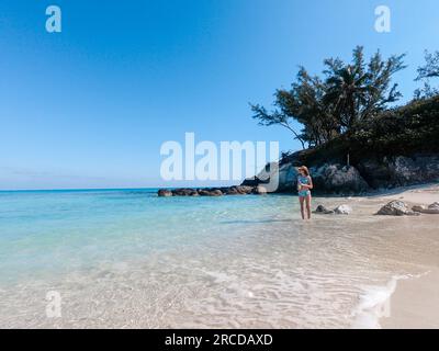 Adolescente debout dans l'eau claire des Bahamas portant un maillot de bain Banque D'Images