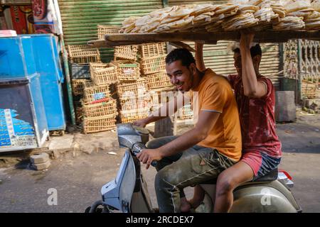 Des jeunes hommes livrent du pain sur une moto au Caire, en Égypte Banque D'Images