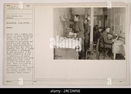 Image : la photographie représente le 1st Lt. Paul J. Bank HR, INF. États-Unis, avec le Sgt James A. Buchanan et le Pvts. William M. Loomis et Leonard M. Thornburgh, travaillant au laboratoire de la sous-section G-2-D de l'état-major général. L'équipe est responsable de l'édition des légendes officielles des photographies et des films pris par les photographes de signal corps pour assurer l'exactitude historique. Le lieu de la photographie est Vincennes, Seine, France. Banque D'Images