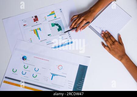 Les mains touchant les illustrations du tableau des tartes à plat reposent sur la table des discussions en table ronde Banque D'Images
