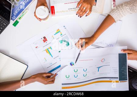 Les mains touchant les illustrations du tableau des tartes à plat reposent sur la table des discussions en table ronde Banque D'Images