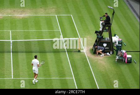 Novak Djokovic (à gauche) parle avec le président-arbitre Richard Haigh après un appel d'empêchement lors du match de demi-finale des gentlemen's Singles contre Jannik Sinner le douzième jour des Championnats de Wimbledon 2023 au All England Lawn tennis and Croquet Club à Wimbledon. Date de la photo : Vendredi 14 juillet 2023. Banque D'Images