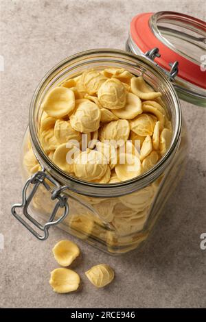 Bocal en verre avec des pâtes Orecchiette crues en gros plan vu du dessus Banque D'Images