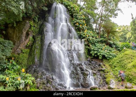 Cascade dans le jardin botanique de Ribeira do Guilherme dans le Nordeste avec des touristes, île Sao Miguel aux Açores. Banque D'Images