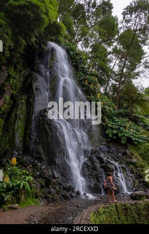 Cascade dans le jardin botanique de Ribeira do Guilherme dans le Nordeste avec des touristes, île Sao Miguel aux Açores. Banque D'Images