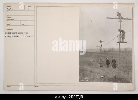 La photographie représente des soldats américains du signal corps posant un câble pendant la première Guerre mondiale. Le travail en ligne, numéroté 67 407, montre les efforts des soldats pour établir des systèmes de communication. La photographie a été prise par le photographe Red Takes ISH, comme l'indique le symbole qui l'accompagne. Banque D'Images