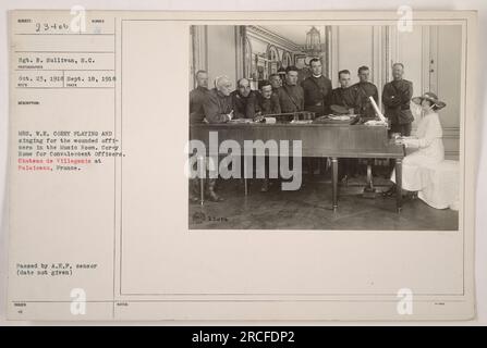 Sergent R. Sullivan capturant Mme W.E. Corey jouant et chantant pour des officiers blessés au Château de Villegenis, Palaiseau, France. Cette photographie a été prise le 18 septembre 1918 et a été émise avec l'approbation du censeur de l'A.E.P. Le décor est la salle de musique du Corey Home pour officiers de convalescence. Banque D'Images