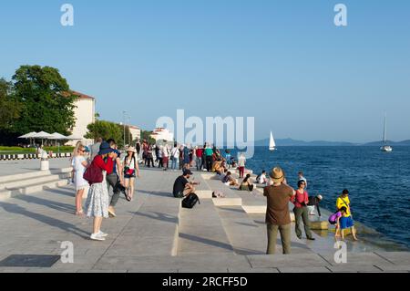 Zadar, Croatie - juin 2019 : les touristes visitent et apprécient l'attraction célèbre, l'installation d'orgue de mer, instrument de musique qui joue de la musique par la mer wav Banque D'Images