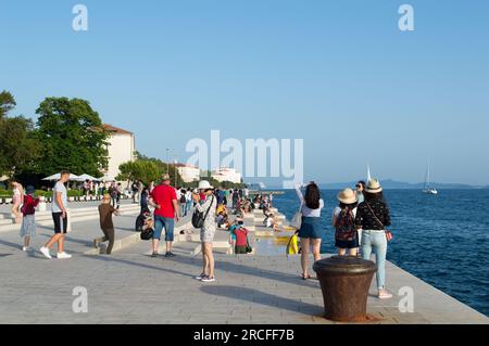 Zadar, Croatie - juin 2019 : les touristes visitent et apprécient l'attraction célèbre, l'installation d'orgue de mer, instrument de musique qui joue de la musique par la mer wav Banque D'Images