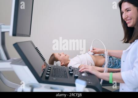 Mignon enfant se trouve sur un canapé médical dans la salle d'échographie Banque D'Images