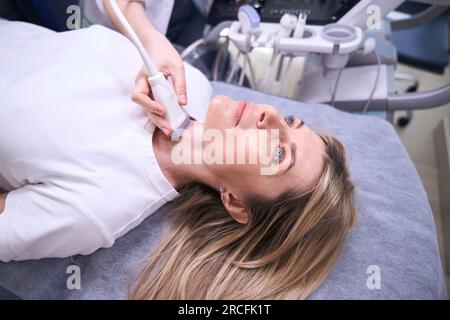 Femme blonde à la clinique de l'échographie thyroïdienne Banque D'Images