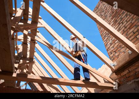 Femme ingénieur du bâtiment marchant sur des poutres de soutien de la structure de plafond Banque D'Images