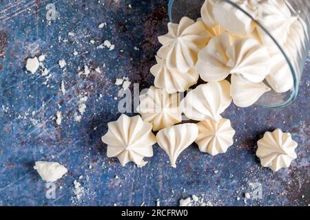 Petites meringues blanches sur fond coloré. Gros plan Banque D'Images