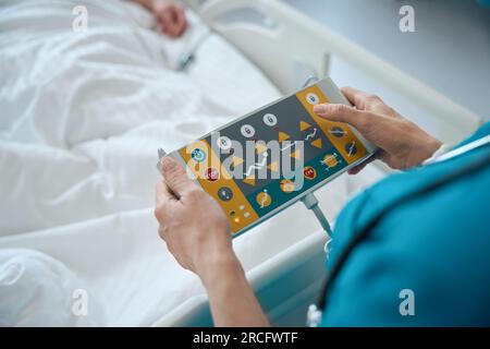 Mains du médecin appuyant sur les boutons du panneau de commande du superviseur dans la salle Banque D'Images