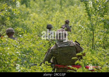 Bemowo Piskie, Pologne. 5 juillet 2023. ÉTATS-UNIS Des soldats de l'armée avec la compagnie Charlie, 1e bataillon, 9e régiment de cavalerie, 1e division de cavalerie, soutenant la 4e division d'infanterie, marchent à travers une zone boisée lors d'un exercice de tir réel sur un champ de tir de la zone d'entraînement de Bemowo Piskie, juillet 5. Le 4th Inf. La mission de Div. En Europe est de s'engager dans des entraînements et des exercices multinationaux à travers le continent, en travaillant aux côtés des alliés de l'OTAN et des partenaires de sécurité régionaux pour fournir des forces crédibles au combat au V corps, le corps avancé américain déployé en Europe. (Image de crédit : © États-Unis Army/ZUMA Press Wire/ZUMAPRE Banque D'Images