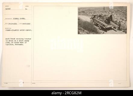 Un camion Mack transportant un tracteur est vu coincé sur une courte route sablonneuse, située à 20 miles à l'ouest d'Ogallala, Nebraska. Cette image capture un moment du convoi Trans-Atlantic Motor pendant la première Guerre mondiale. Date de réception : 10 mars 1921. Date de prise : 6 août 1919. Photographe : signal corps. Numéro de référence de l'image : 64516. Banque D'Images