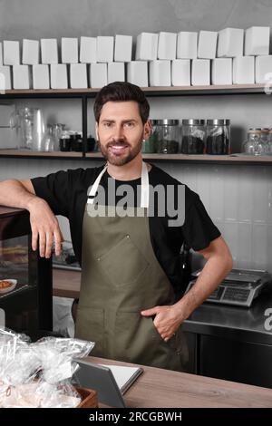Portrait de vendeur heureux au comptoir de caisse dans la boulangerie Banque D'Images