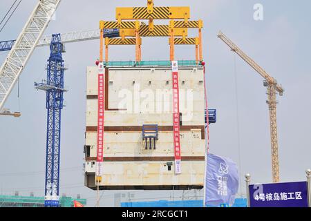 YANTAI, CHINE - 14 JUILLET 2023 - Une grande grue soulève le module CA20 dans l'île nucléaire de l'unité 4 de la centrale nucléaire de Shandong Haiyang en Y Banque D'Images