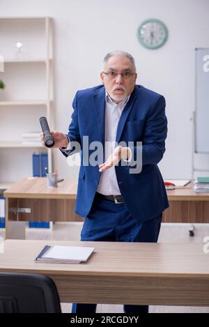 Ancien enseignant tenant la lampe-stylo dans la salle de classe Banque D'Images