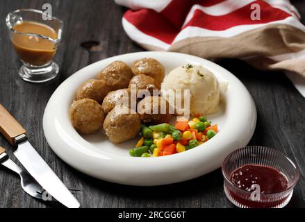 Boulettes de viande suédoises avec sauce aux lingonberges et purée de pommes de terre sur une assiette blanche. Banque D'Images