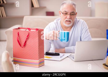 Vieux homme avec beaucoup de sacs dans le concept de Noël à l'intérieur Banque D'Images