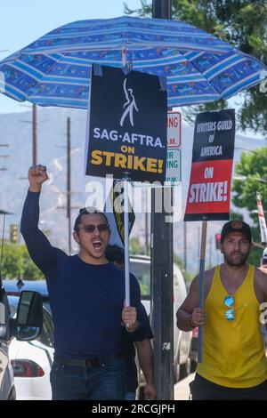 Los Angeles, États-Unis. 14 juillet 2023. Des écrivains et des acteurs frappants marchent avec des piquets devant le studio Walt Disney Company à Burbank. Jeudi, le Conseil national du syndicat a voté à l'unanimité pour émettre un ordre de grève. L'ordre de grève a pris effet jeudi à minuit, et à partir de vendredi matin, SAG-AFTRA a rejoint les lignes de piquetage avec la Writers Guild of America, qui est dans la 11e semaine de son propre débrayage contre l'Alliance of Motion Picture and Television Producers. (Photo de Ringo Chiu/SOPA Images/Sipa USA) crédit : SIPA USA/Alamy Live News Banque D'Images