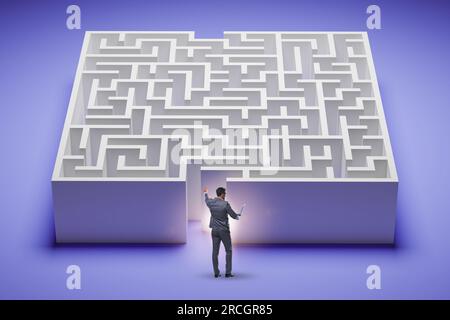 Homme d'affaires essayant de trouver un moyen de sortir du labyrinthe Banque D'Images