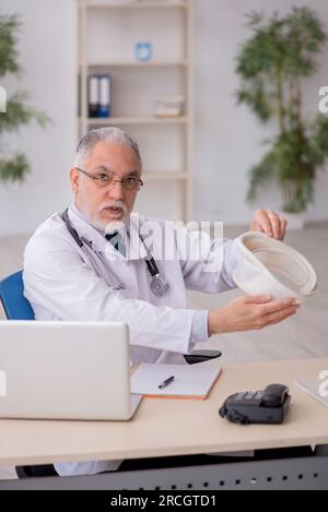 Vieux médecin tenant l'orthèse cervicale à la clinique Banque D'Images