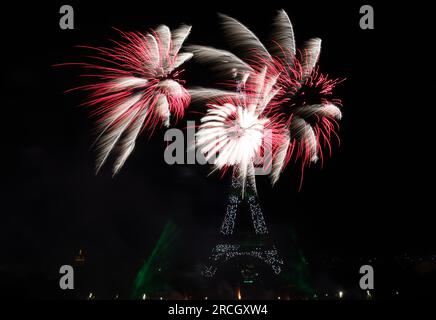 Paris, France. 14 juillet 2023. Les feux d'artifice explosent près de la Tour Eiffel lors des célébrations du jour de la Bastille à Paris, France, le 14 juillet 2023. La France a organisé les célébrations de la fête nationale française, ou Bastille Day, le vendredi. Crédit : Gao Jing/Xinhua/Alamy Live News Banque D'Images