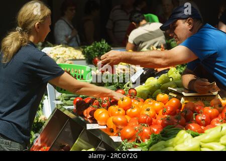 Bucarest, Roumanie. 14 juillet 2023 : un agriculteur roumain vend des tomates lors de l'inauguration du marché agroalimentaire 'Piata Norilor' par la mairie du secteur 4, Bucarest. Piața Norilor, le plus récent et l'un des plus modernes de la capitale, a été reconstruit sur son ancien site après la démolition de l'ancien marché d'un étage et a maintenant deux étages, Au rez-de-chaussée se trouve un parking et au premier étage se trouve le marché agroalimentaire adressé aux agriculteurs roumains. Crédit : Lucian Alecu/Alamy Live News Banque D'Images