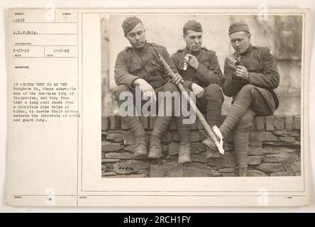 Soldats de l'armée d'occupation américaine faisant une pause à Cochem, en Allemagne. On les voit fumer des pipes à tabac pour se détendre et soulager le stress pendant leur exercice de forage et de garde. Cette photographie a été prise le 27 mars 1919 par un photographe des Forces expéditionnaires américaines (AEF). (Description basée sur la légende originale) Banque D'Images