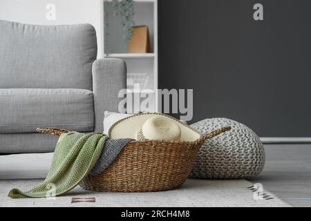 Panier en osier avec chapeau et couverture dans le salon Banque D'Images