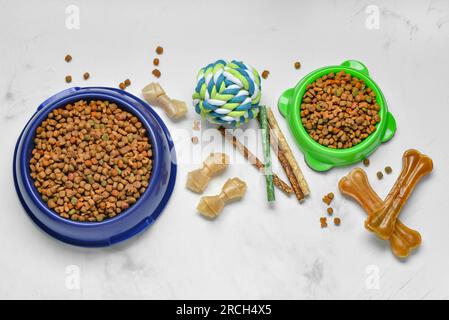 Composition avec différents aliments pour chiens et boule de jouet sur fond clair Banque D'Images