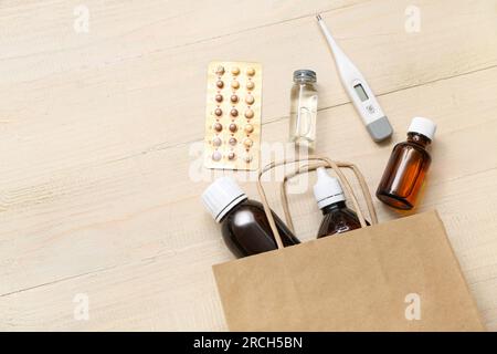 Sac à provisions avec différents médicaments sur fond en bois Banque D'Images