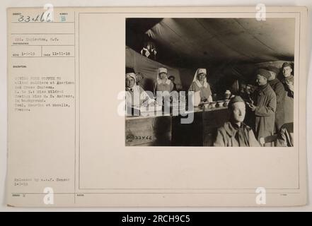 Le caporal Ingleston, un soldat américain, fournit gratuitement du café aux soldats alliés à la cantine de la Croix-Rouge américaine à Toul, en Meurthe et Moselle, en France, pendant la première Guerre mondiale. Deux femmes, Mlle Mildred Cowing et Mlle M.D. Andress, peut être vu en arrière-plan. La photographie a été prise le 11 novembre 1918 et diffusée par l'A.S.F. Censurer le 7 janvier 1919. Banque D'Images