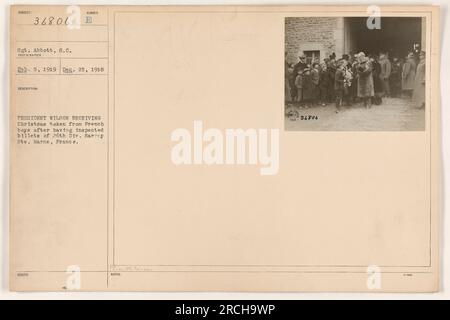 Le président Wilson reçoit un jeton de Noël de garçons français après avoir inspecté les billettes de la 26e division à Sarrey hte. Marne, France. Photographie prise par le sergent Abbott. La photo est numérotée 111-SC-36806 et a été émise en 1919. Les notes de référence sont incluses sous WC.Tan 3686. Banque D'Images